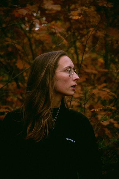 女人黑色水手领衬衫站在棕色树白天
